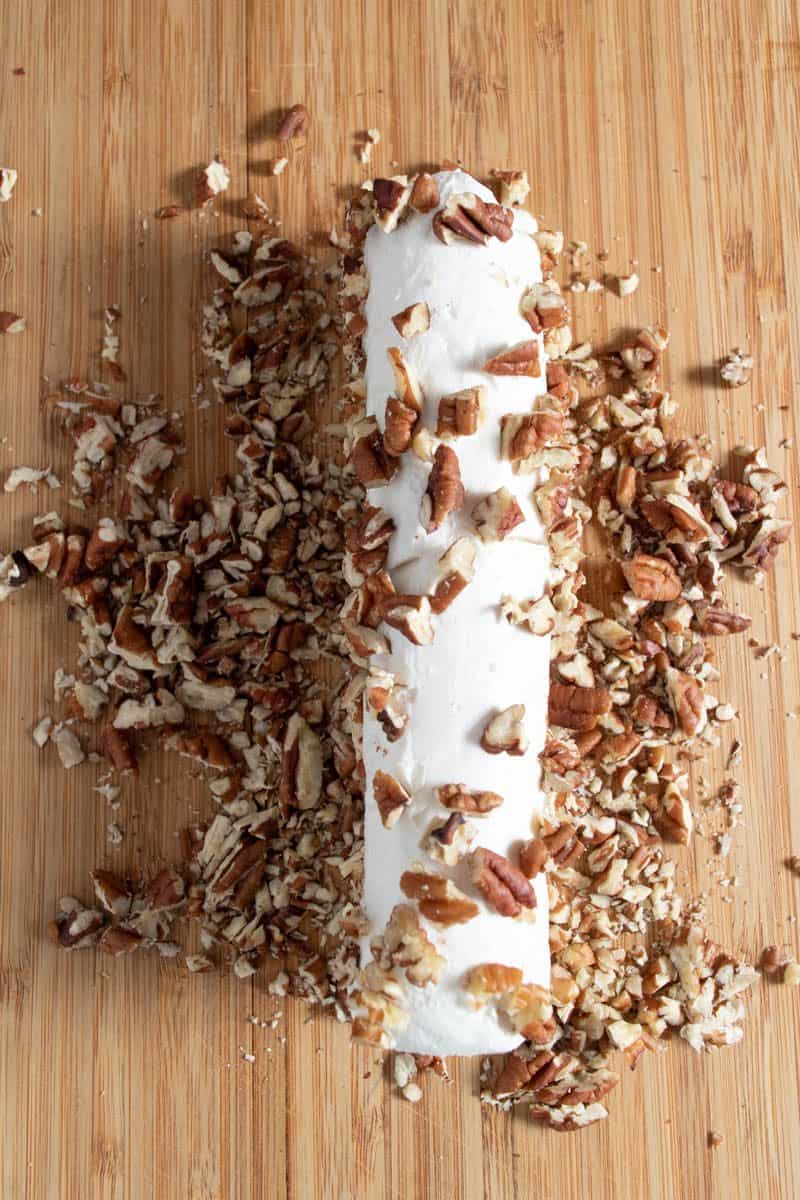 Process of coating cheese log with pecans.