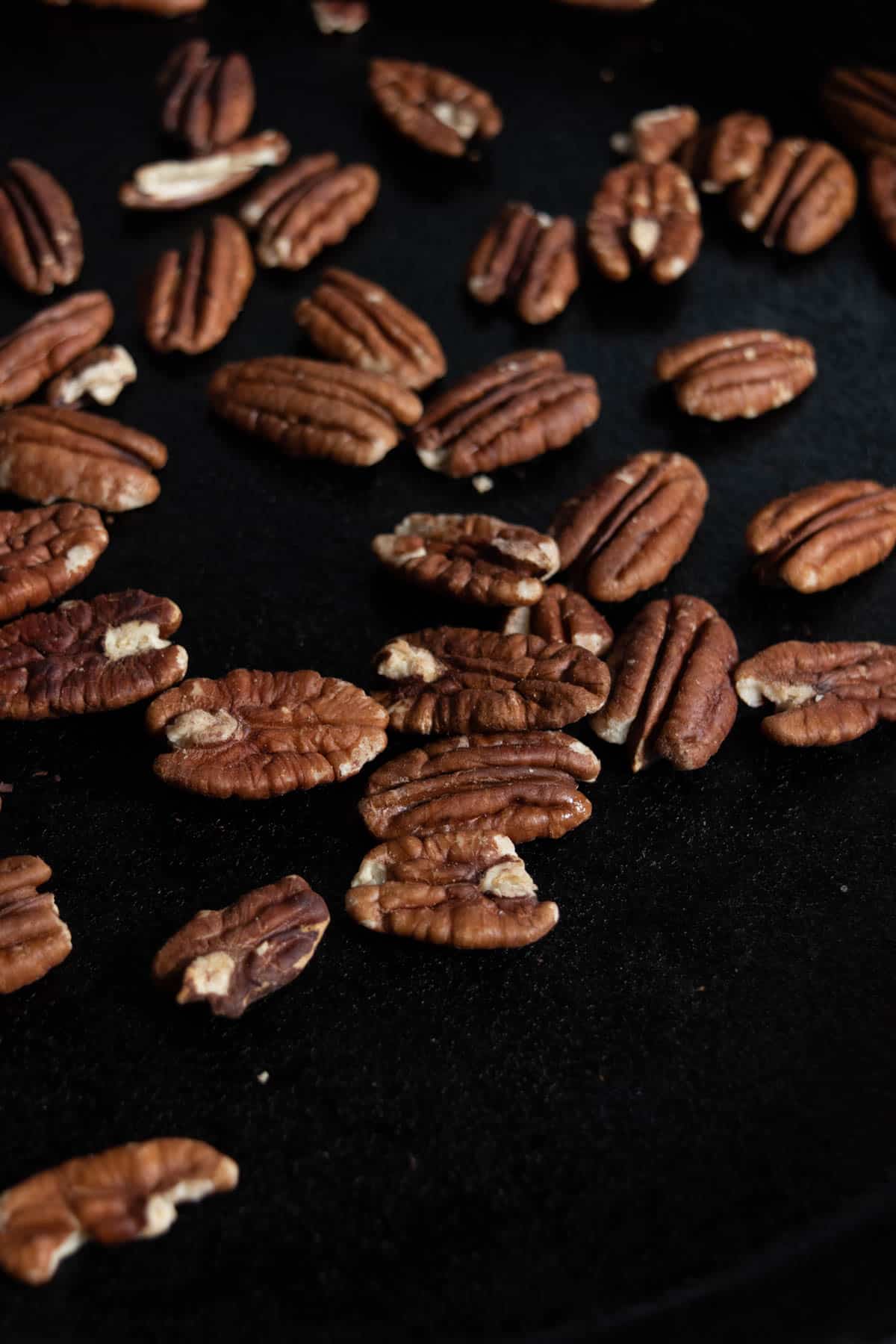Pecans toasting in a cast iron skillet.