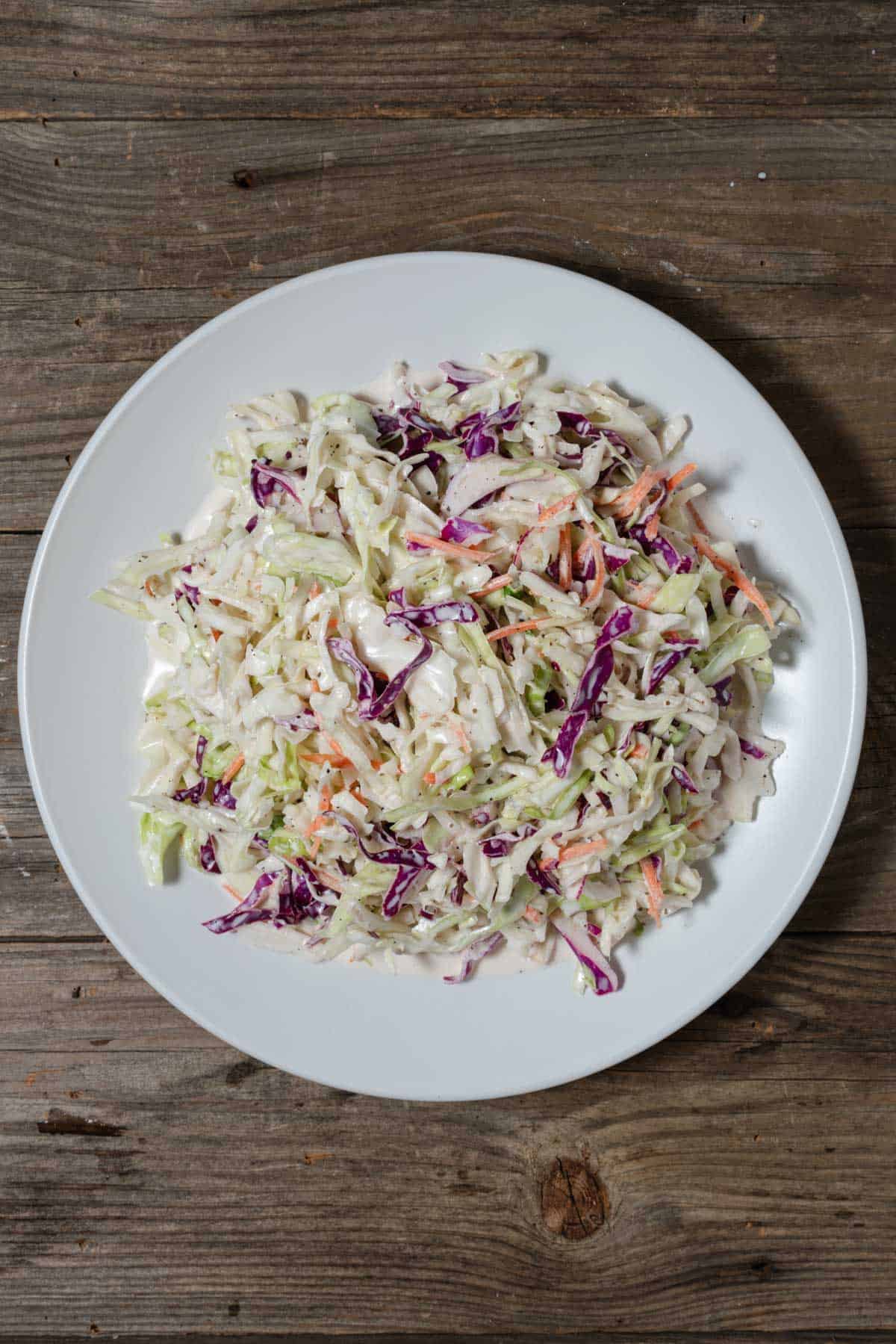 Creamy coleslaw on a white platter.