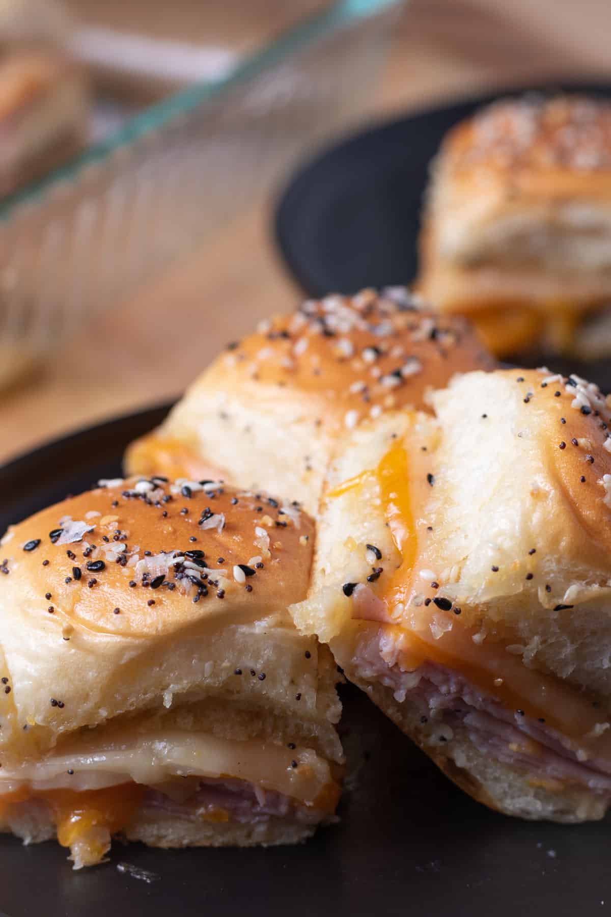 A plate of oven baked ham and cheese sandwiches.