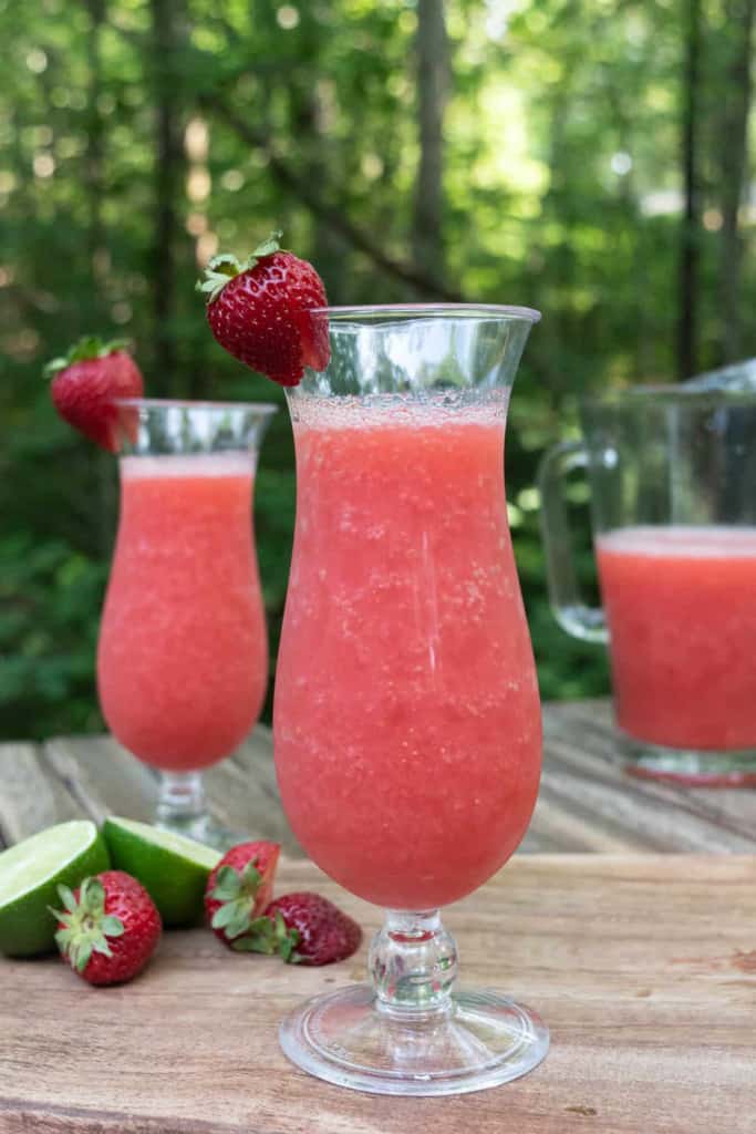 Frozen strawberry daiquiri served outside in a hurricane glass.