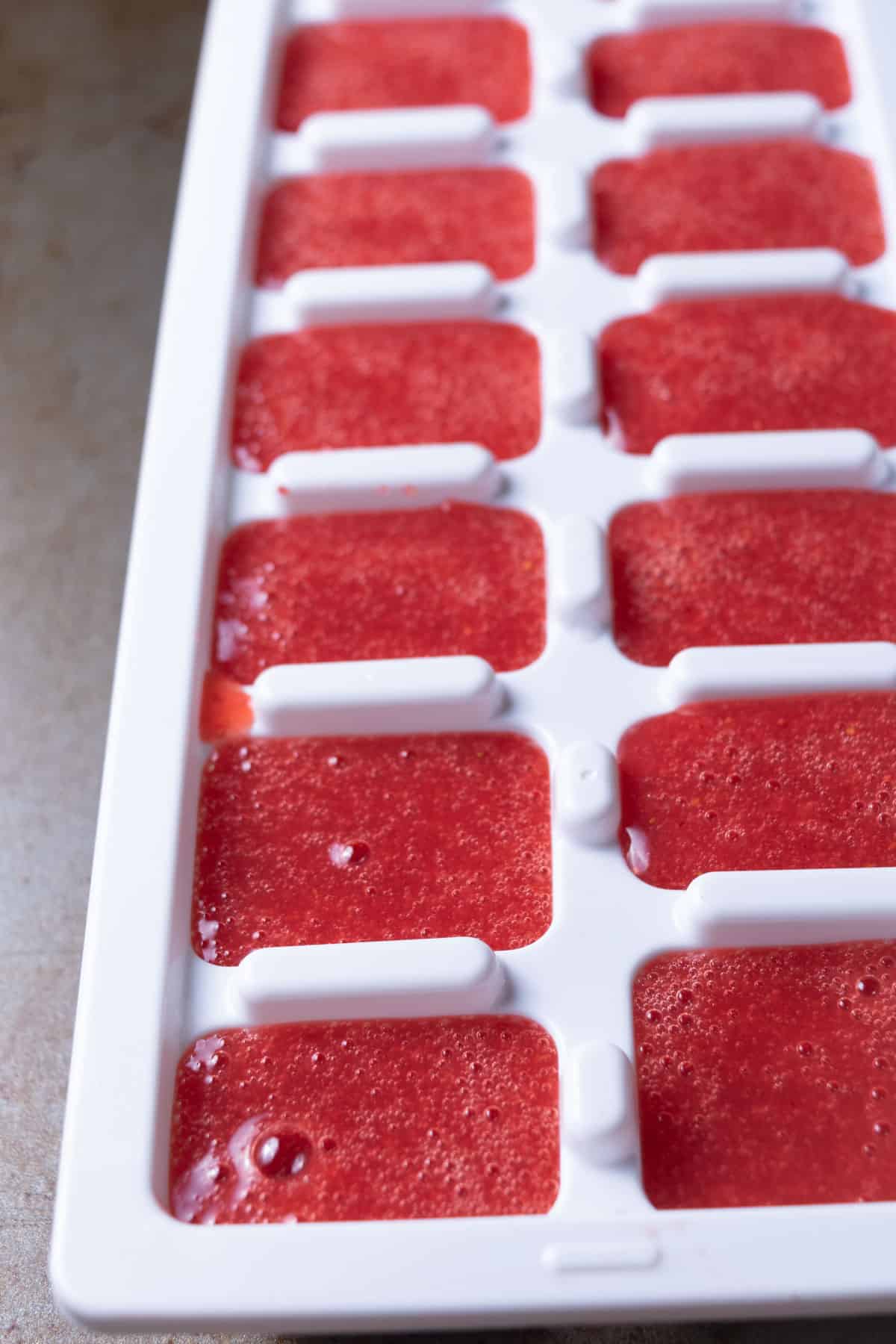 Real strawberry puree in an ice cube tray.