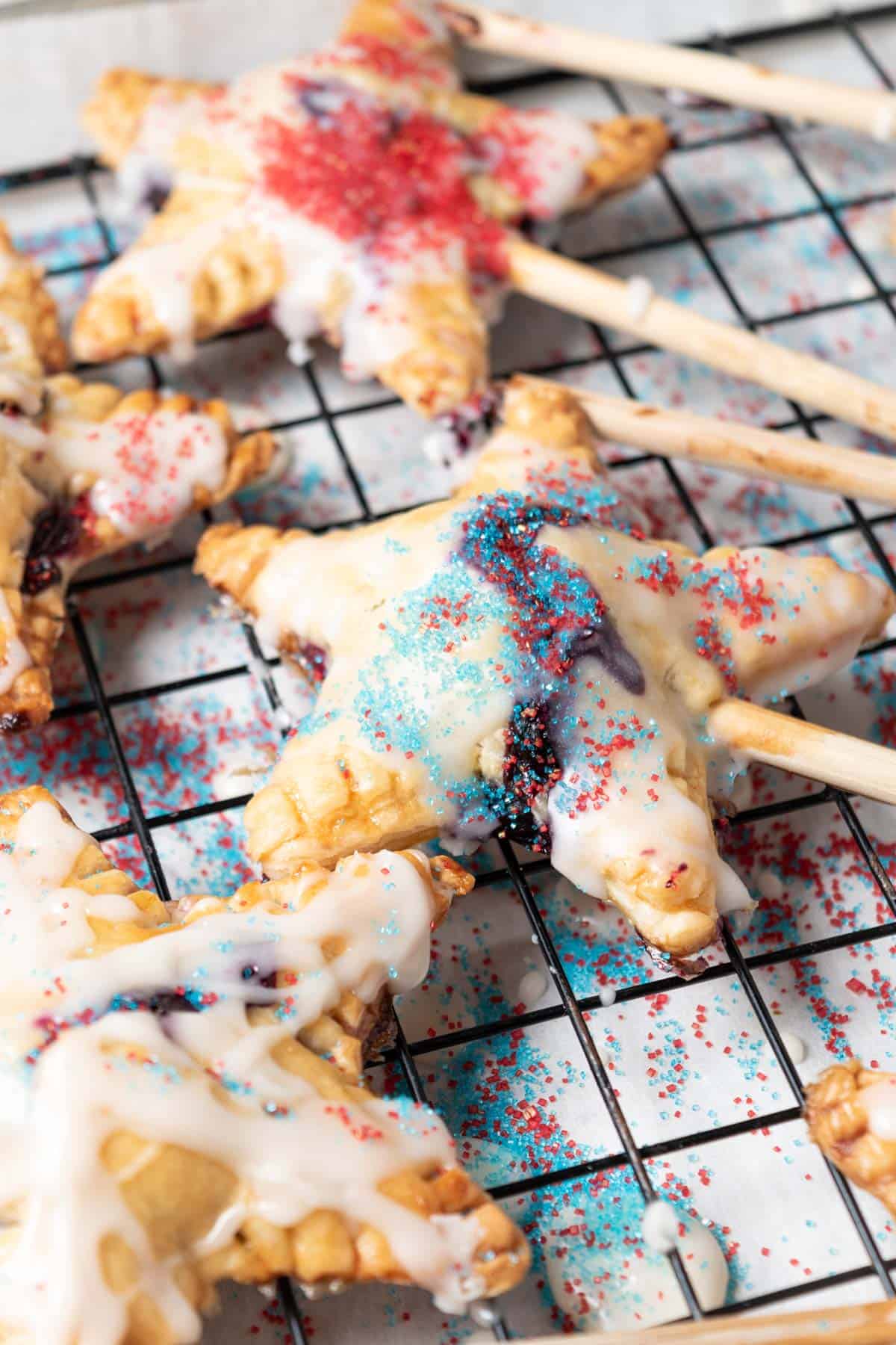 Star shaped blueberry mini pie pops with red and blue sprinkles.