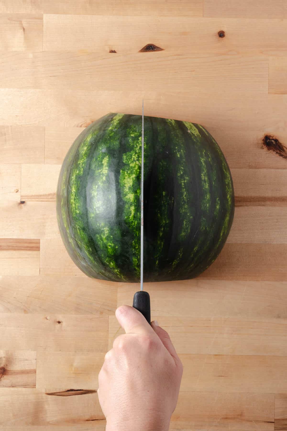 Cutting a watermelon in half.