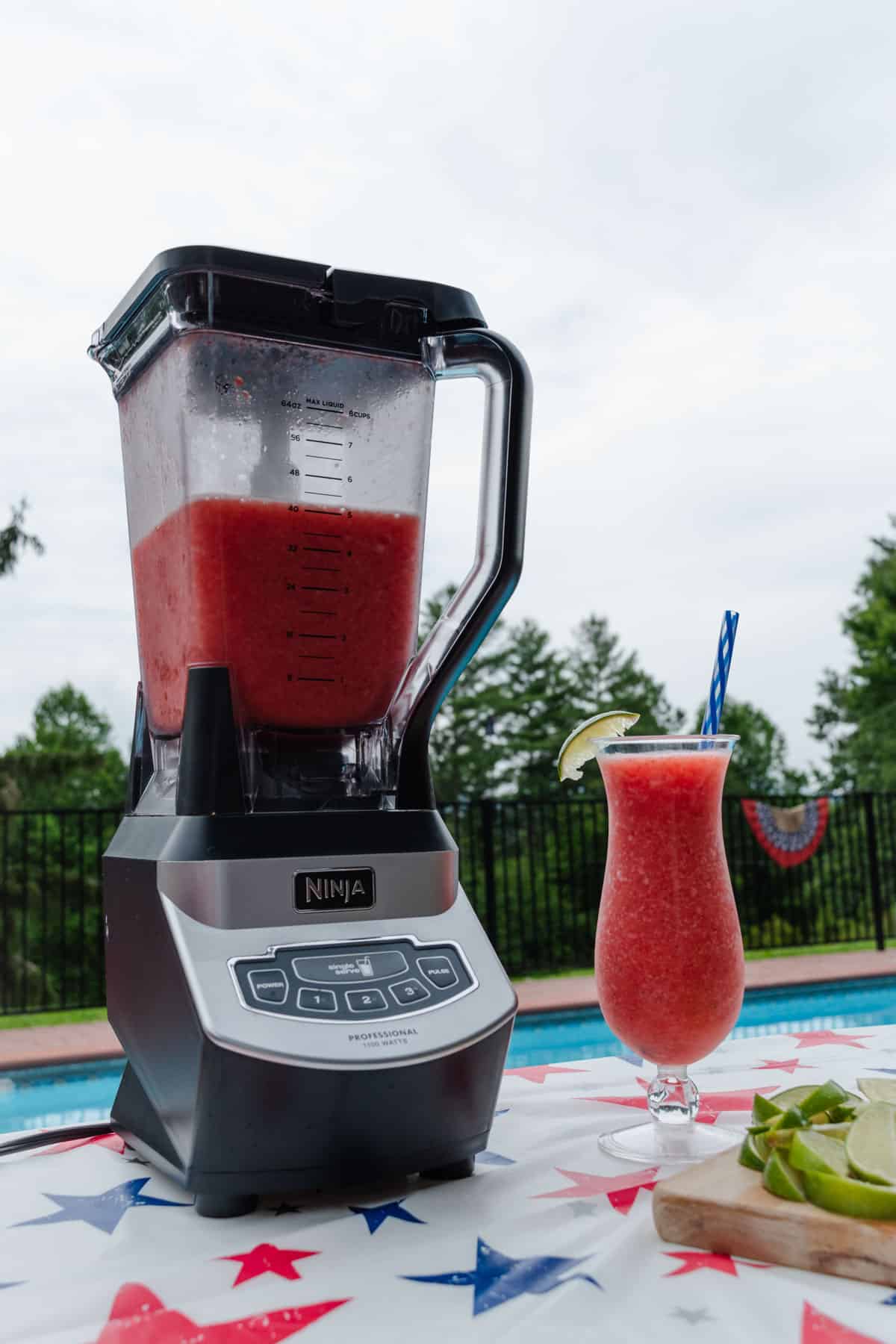 Strawberry daiquiri mocktail outside on a red, white, and blue table.