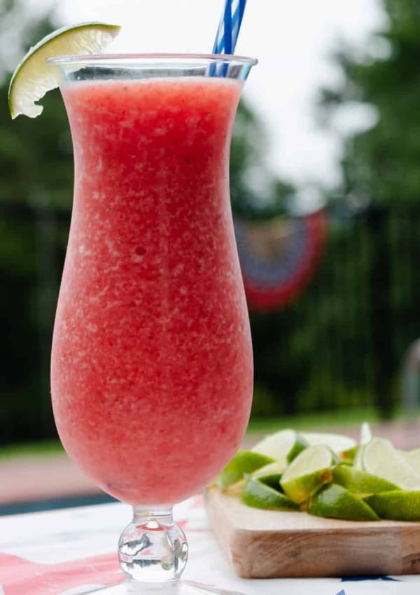 A strawberry daiquiri mocktail outside by a pool.