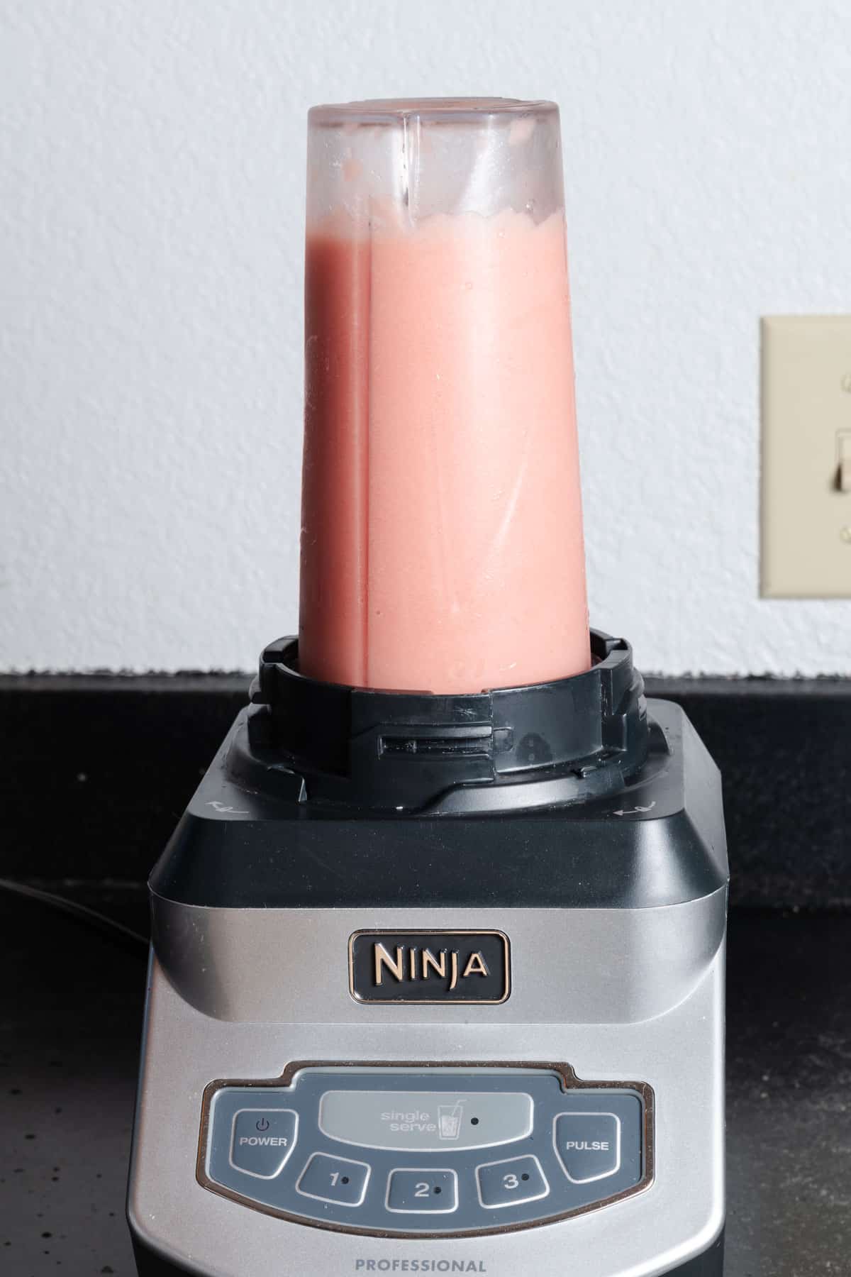 Blending watermelon pineapple and coconut into a delicious beverage.