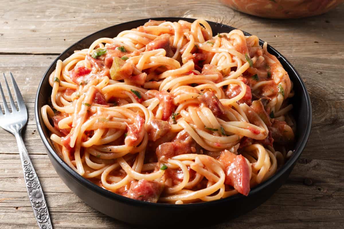 Fresh tomato and brie pasta sauce over a bowl of linguine noodles.