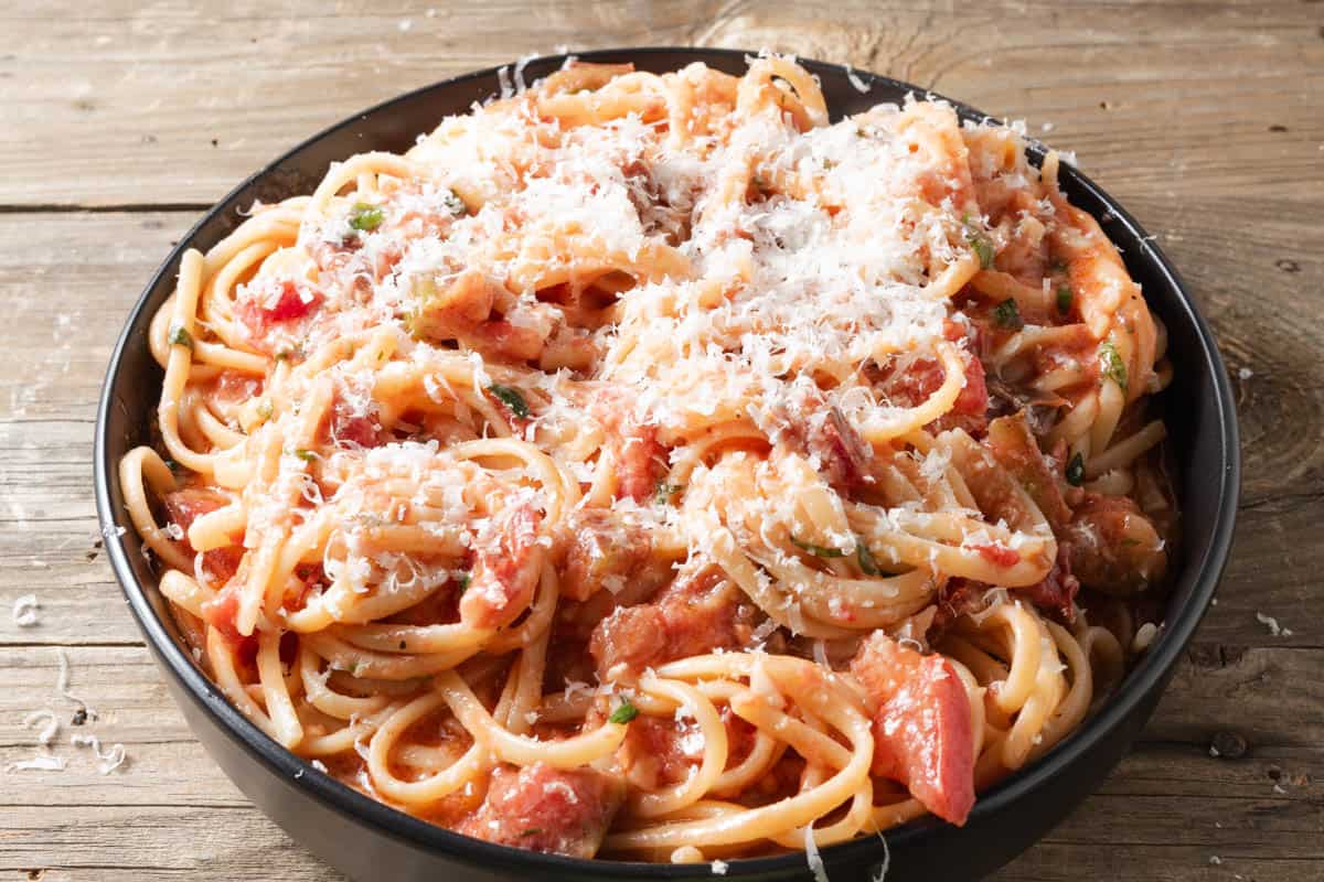 Fresh tomato and brie pasta sauce over a bowl of linguine noodles.