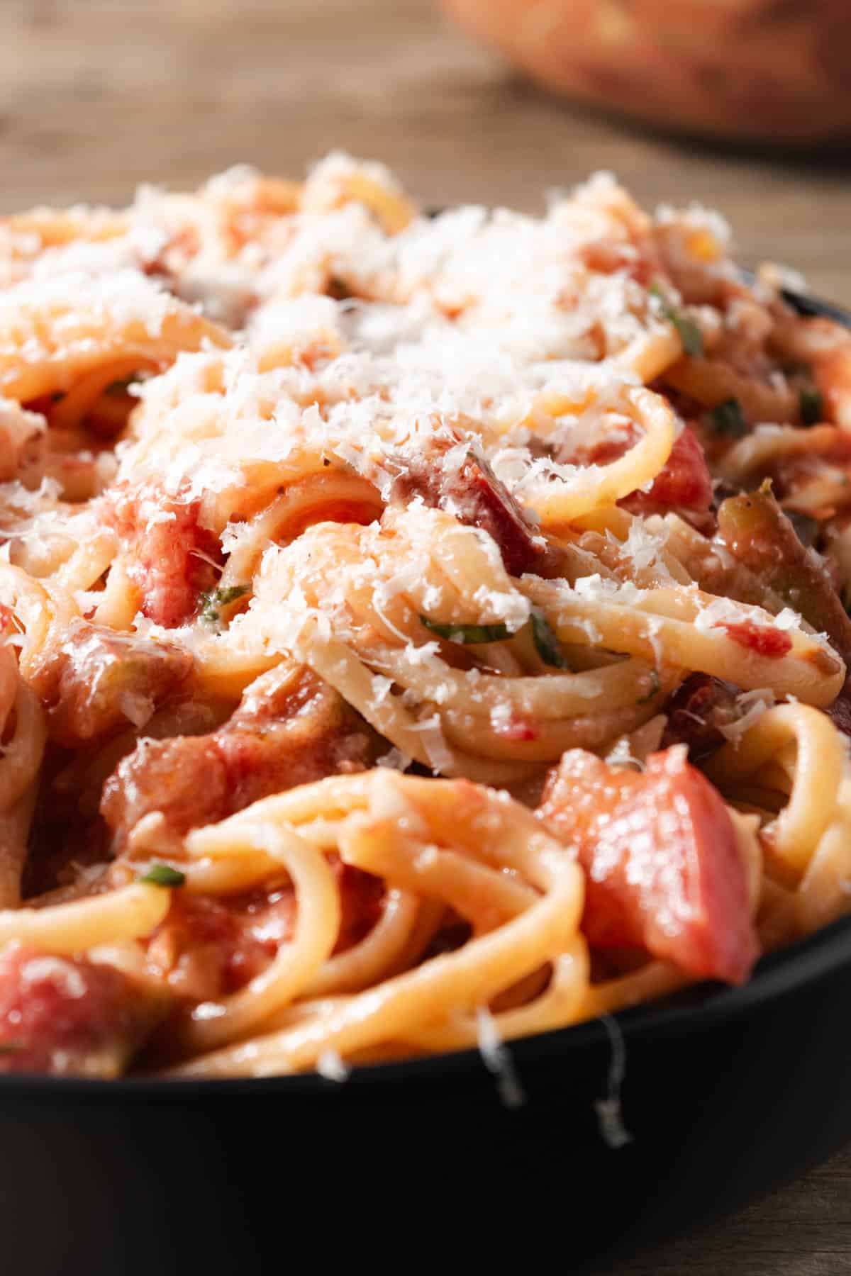 A bowl of tomato linguine with freshly grated parmesan cheese.