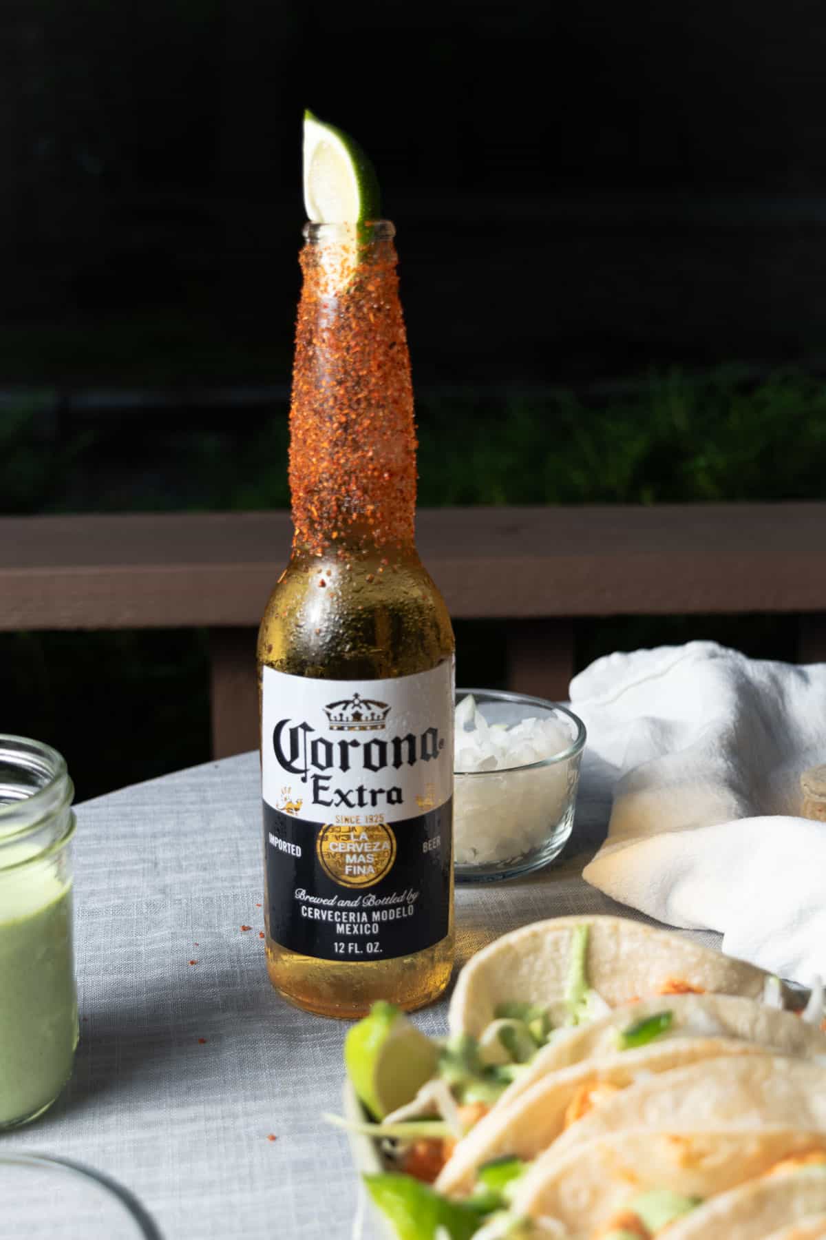 A cerveza dressed with lime and tajin with a platter of shrimp tacos.