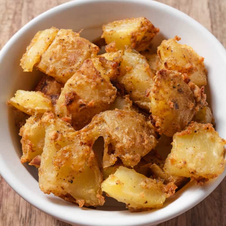 A white bowl of fiesta style crispy Mexican potato bites.