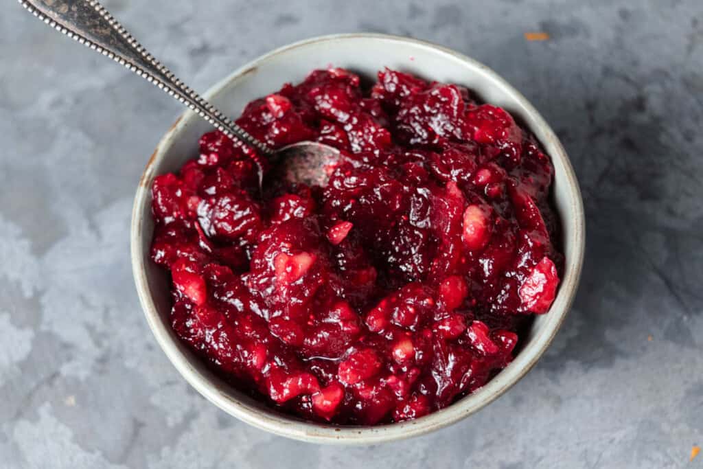 A bowl of homemade whole berry cranberry sauce with orange juice and nuts.