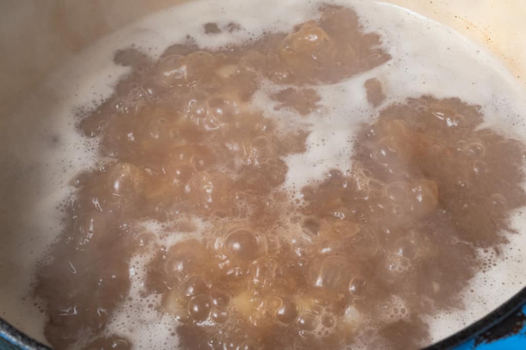 Boiling potatoes in chicken stock.