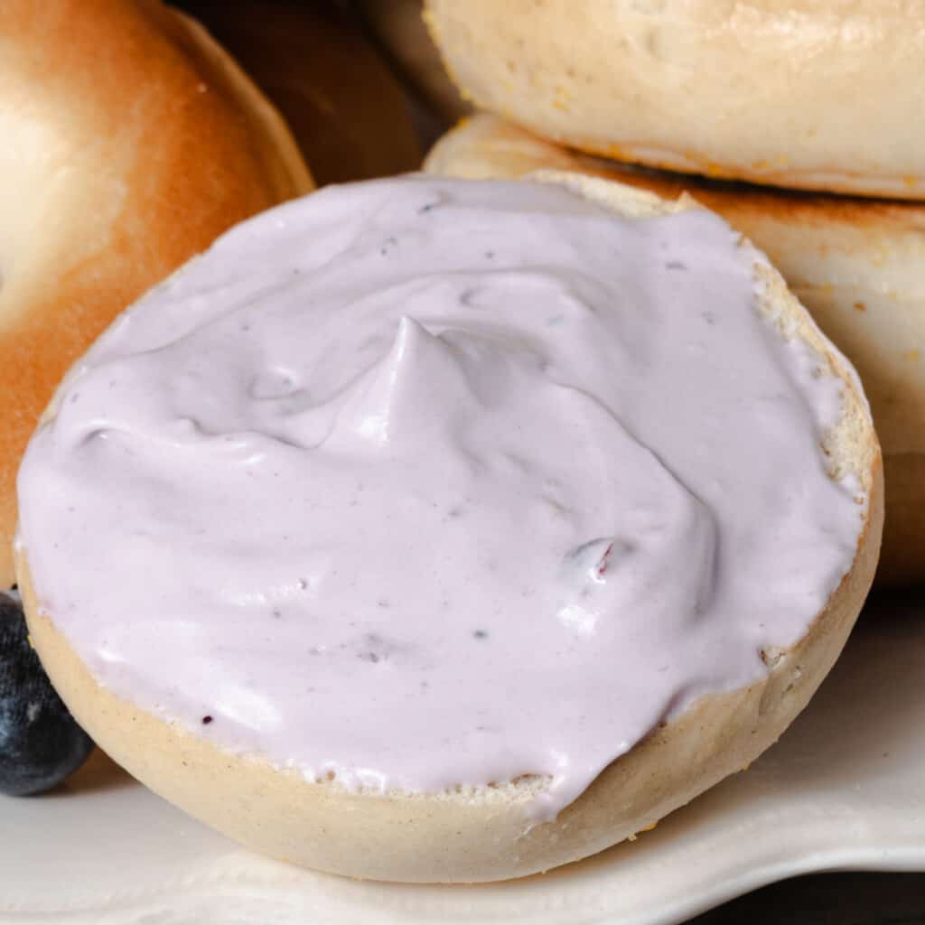 Homemade whipped blueberry cream cheese spread on a bagel.