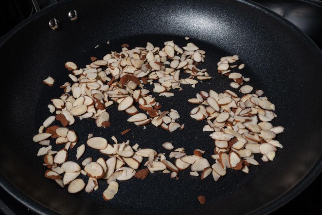 Toasting almond slices in a pan.