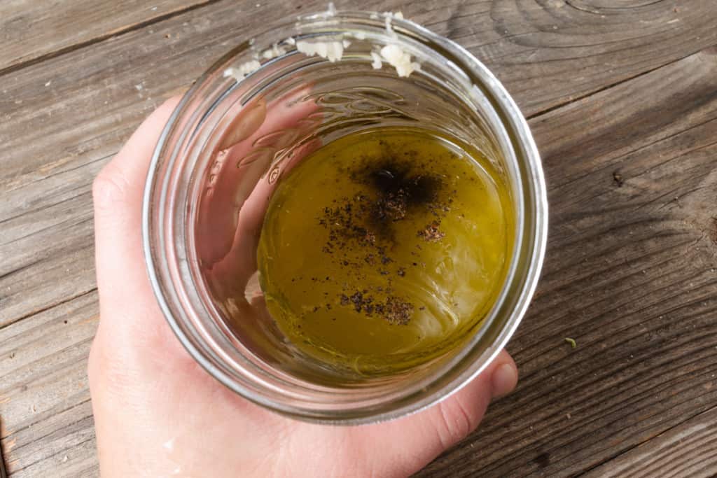 Ingredients for lemon vinaigrette in a jar.