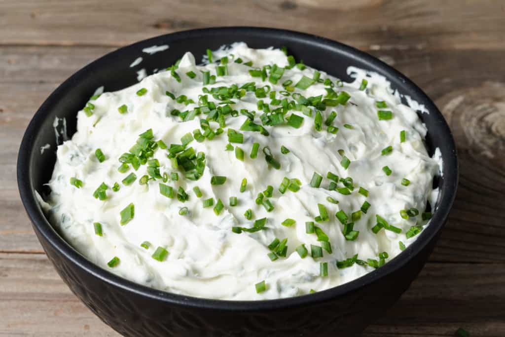 A bowl of homemade double whipped chive and onion cream cheese spread.