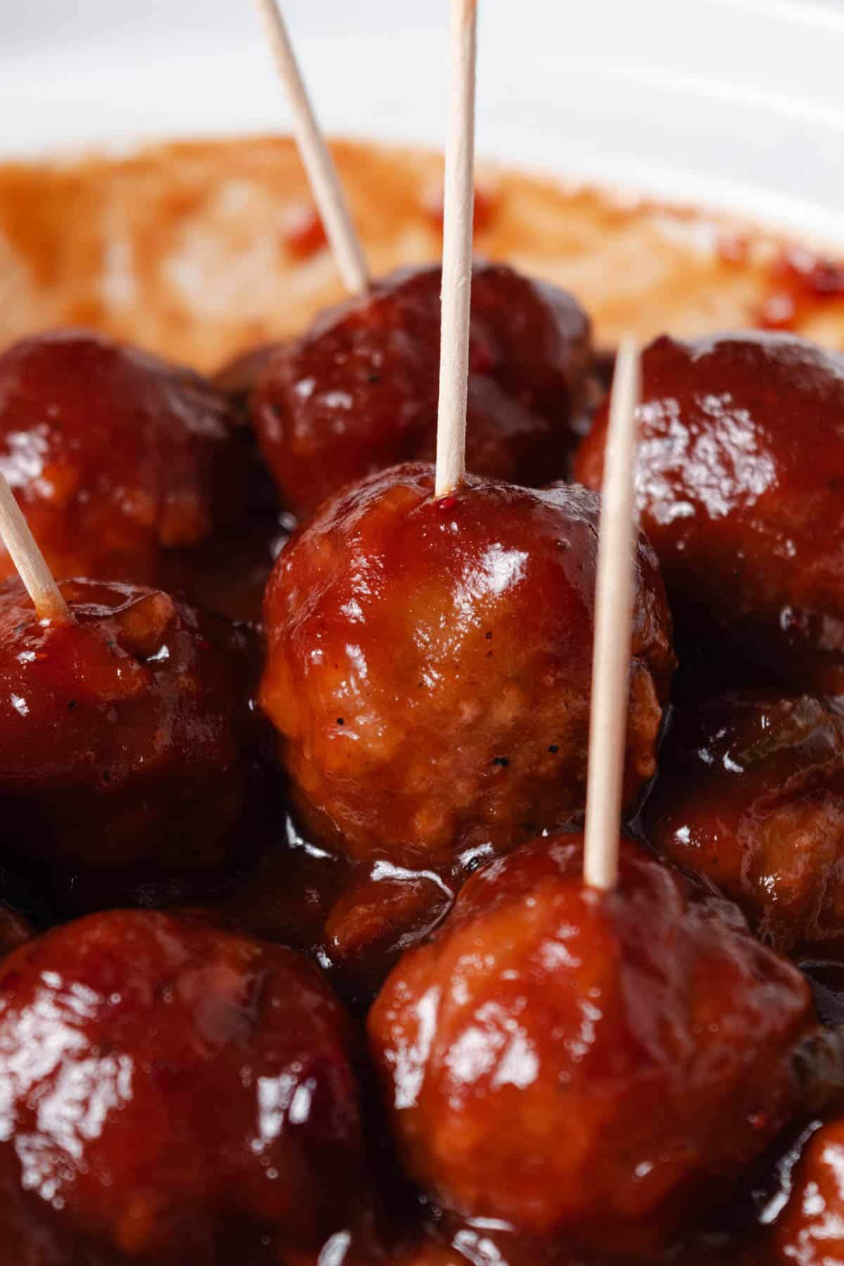 Cocktail cranberry jalapeno meatballs with toothpicks for serving.