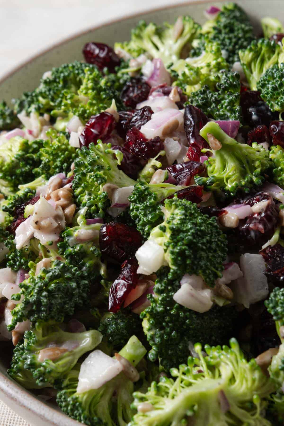 A bowl of crunchy broccoli salad with sweet dried cranberries.