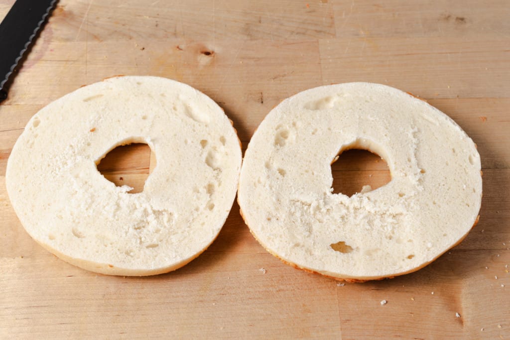 A sliced asiago cheese bagel.