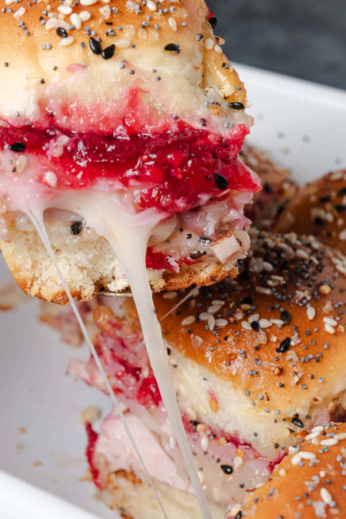 A cheese pull while serving cranberry and turkey sliders.