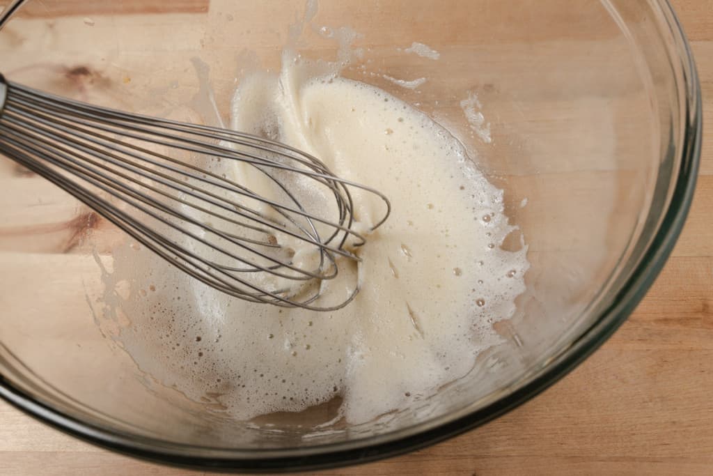 Whisking egg white and vanilla in a mixing bowl.