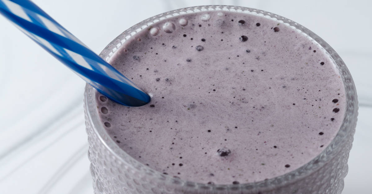 A purple smoothie with a straw.
