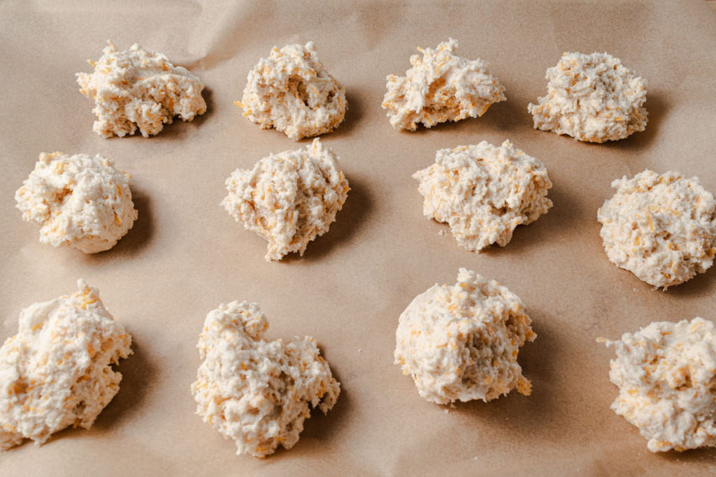 Cheddar biscuit dough on a baking sheet.