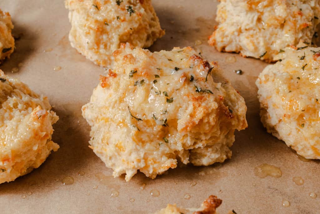 A fresh cheddar biscuit with melted garlic herb butter.