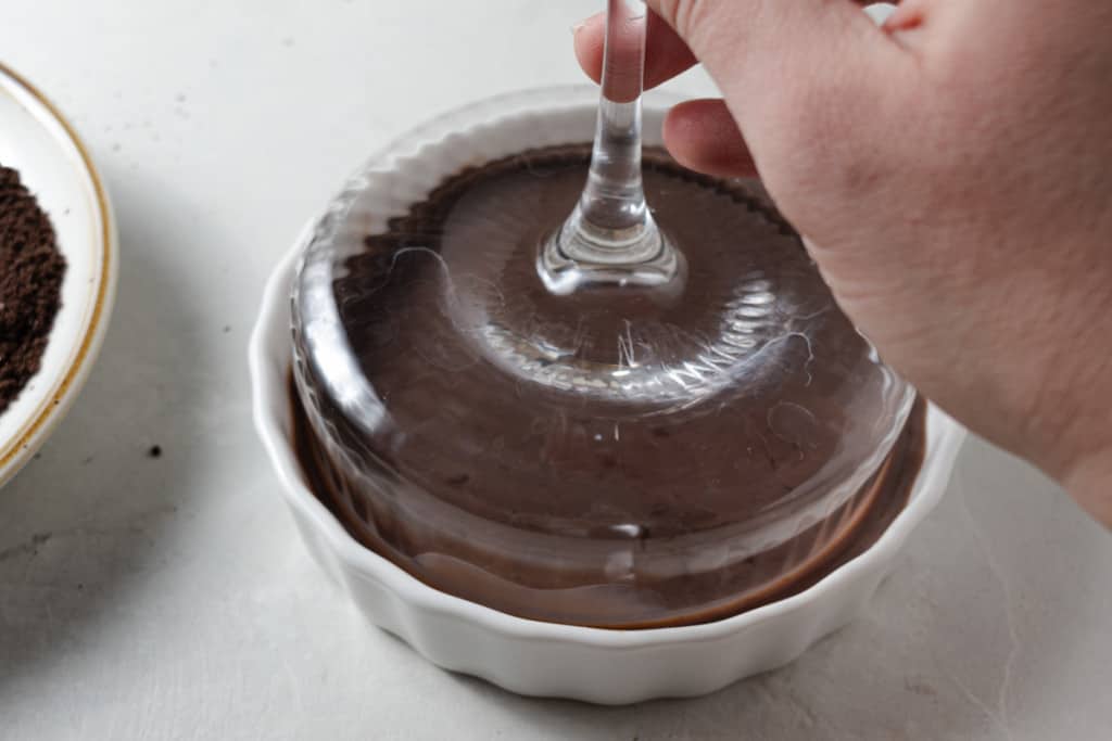 Dipping a coupe martini glass rim in chocolate liqueur.