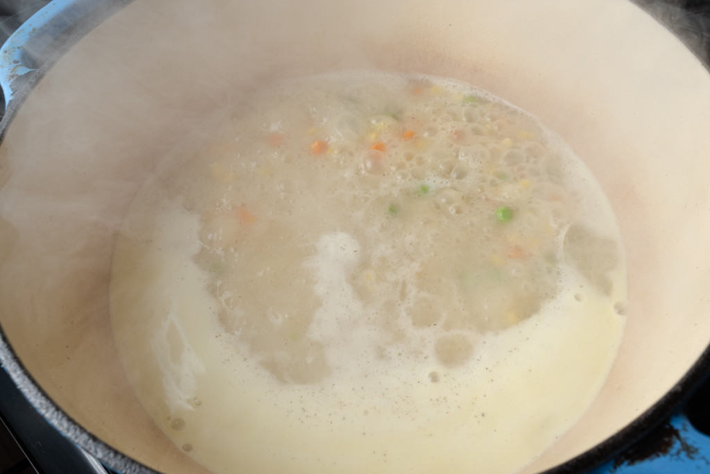 Simmering vegetables in chicken stock and roux.