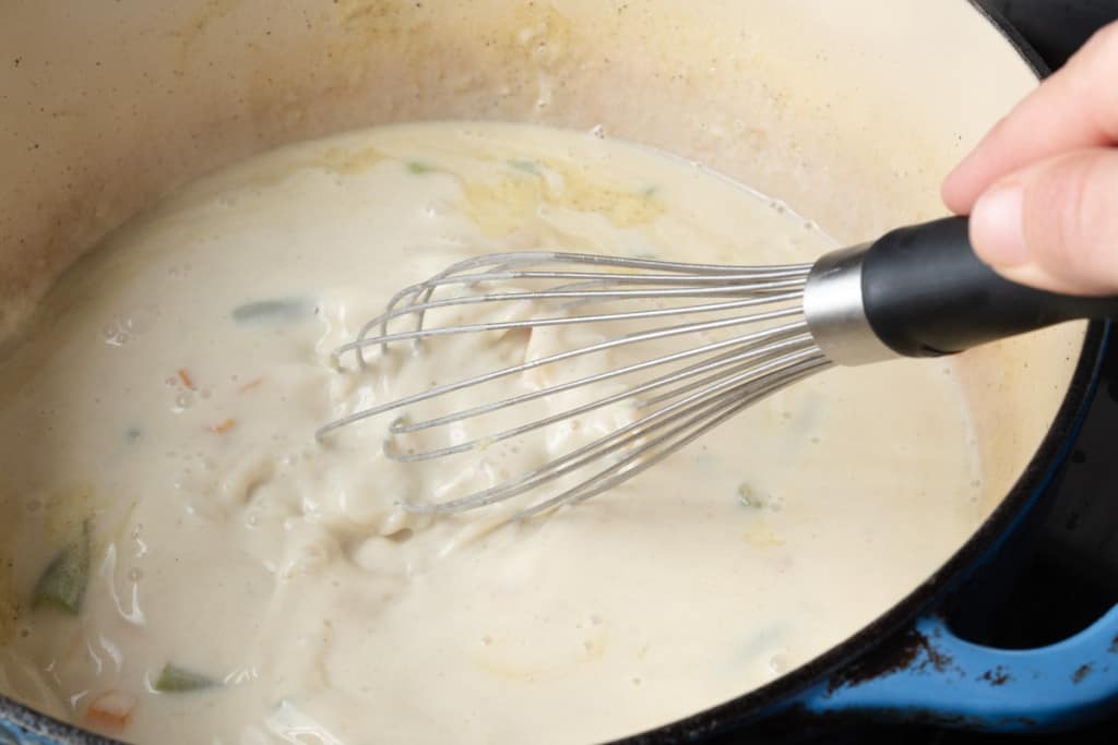 Whisking a pot of creamy vegetable soup.