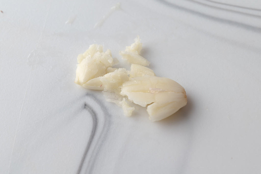 A crushed and peeled clove of garlic.