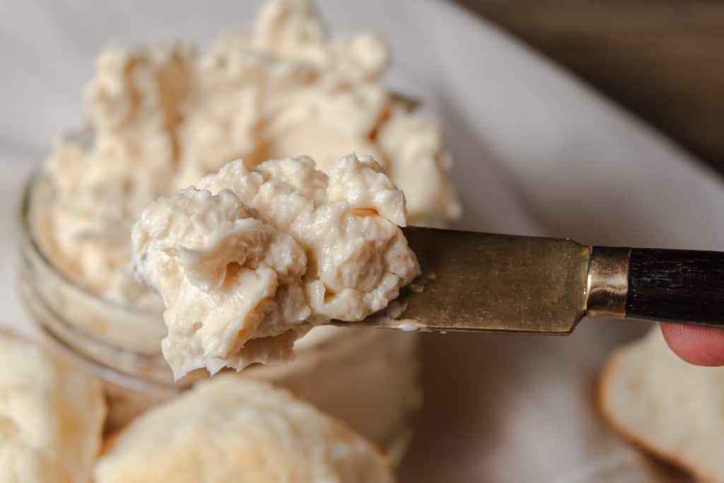 Honey butter on a butter knife, ready to spread on a biscuit.