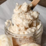 A jar of whipped honey butter with hot homemade biscuits.