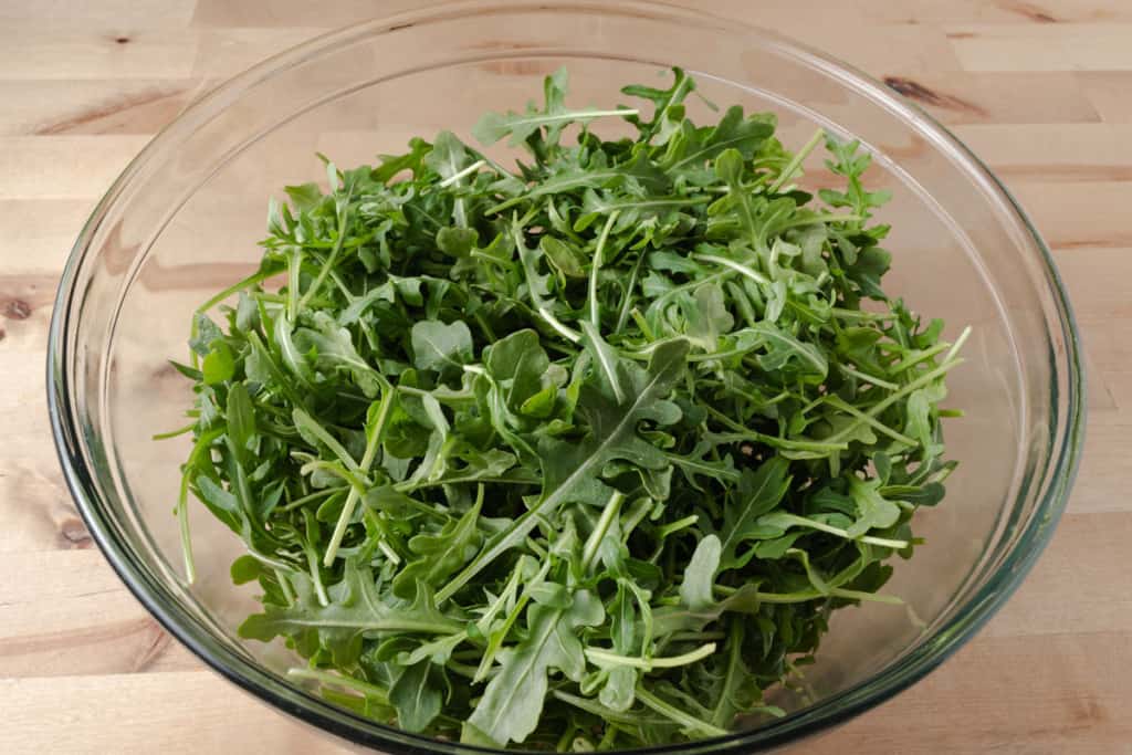 A large bowl of baby arugula.