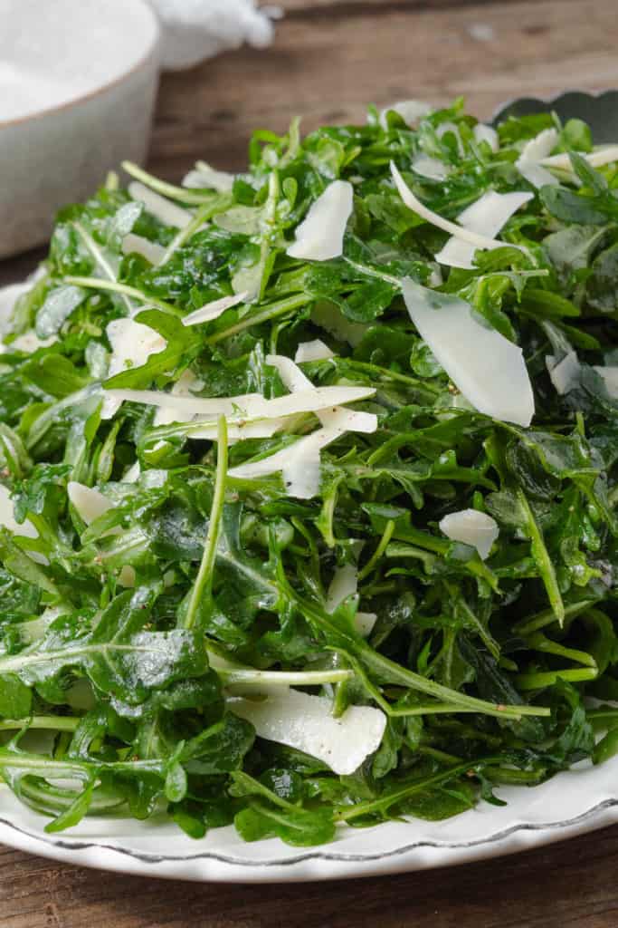 A pile of arugula and parmesan tossed with lemon and extra virgin olive oil.