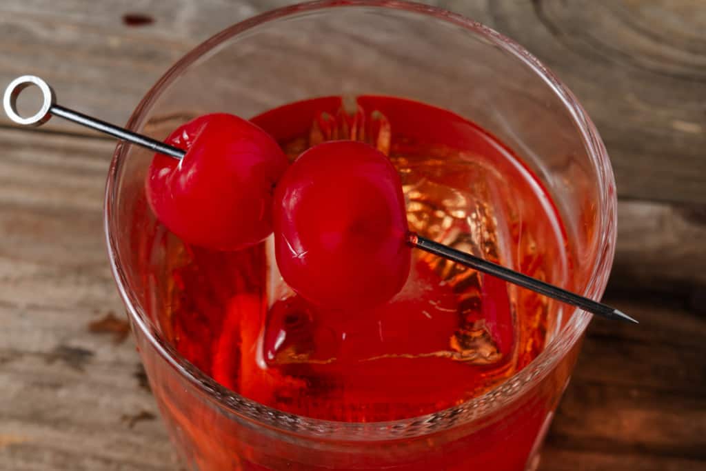 A cherry and chocolate old fashioned cocktail garnished with bourbon soaked cherries.