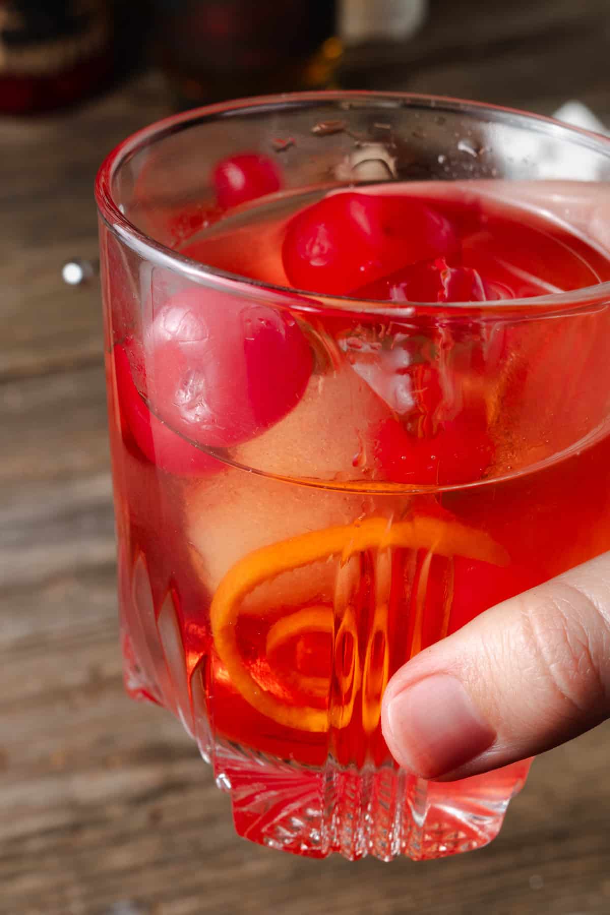 Holding a chocolate and cherry old fashioned.