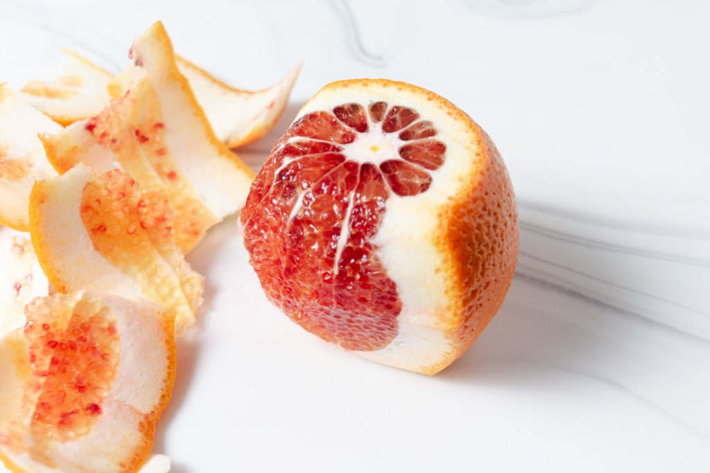 Cutting the peelings and pith off of a blood orange.