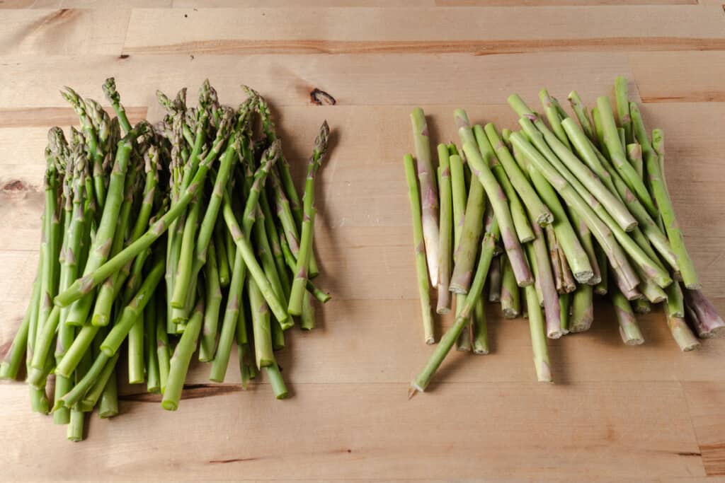 A pile of asparagus with the woody ends snapped off.