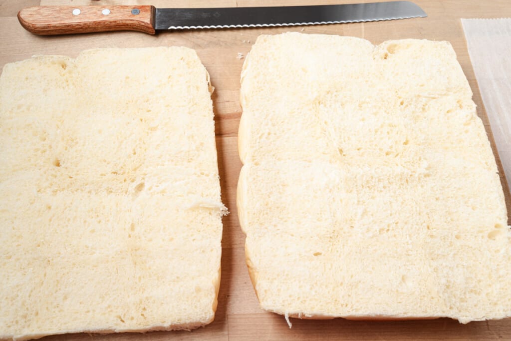 A package of dinner rolls sliced in half.