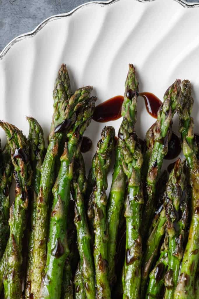 A platter of grilled asparagus with balsamic glaze.