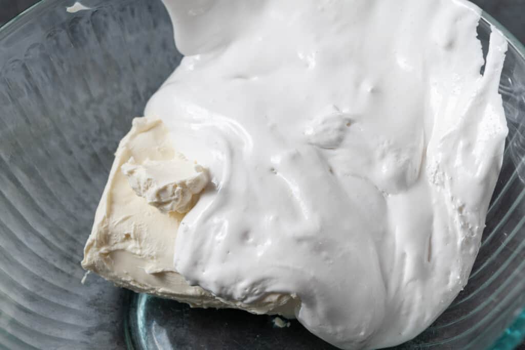 Cream cheese and marshmallow creme in a mixing bowl.