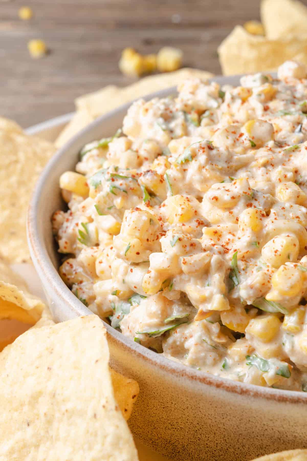 A bowl of Mexican street corn dip with tortilla chips.