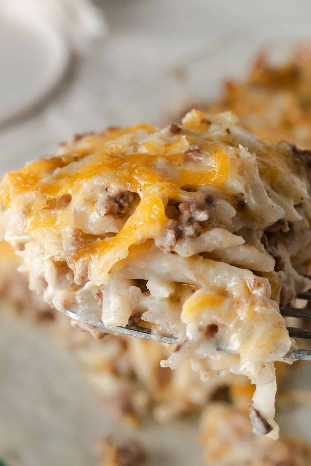 A warm piece of cheesy hamburger hashbrown casserole.