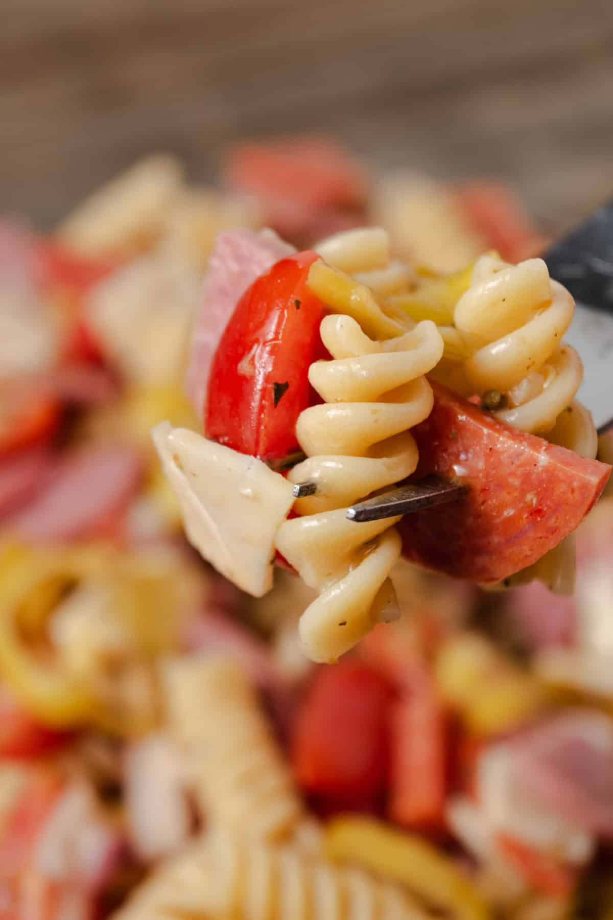 A bite of Italian grinder pasta salad on a fork.