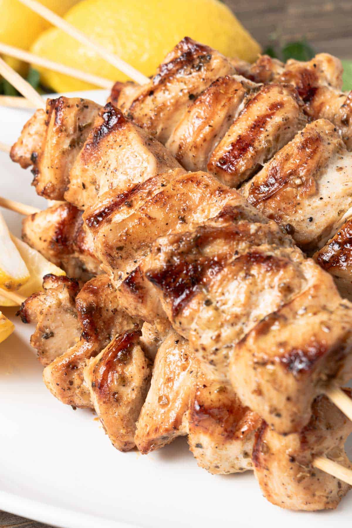 A plate of grilled Greek chicken souvlaki skewers.