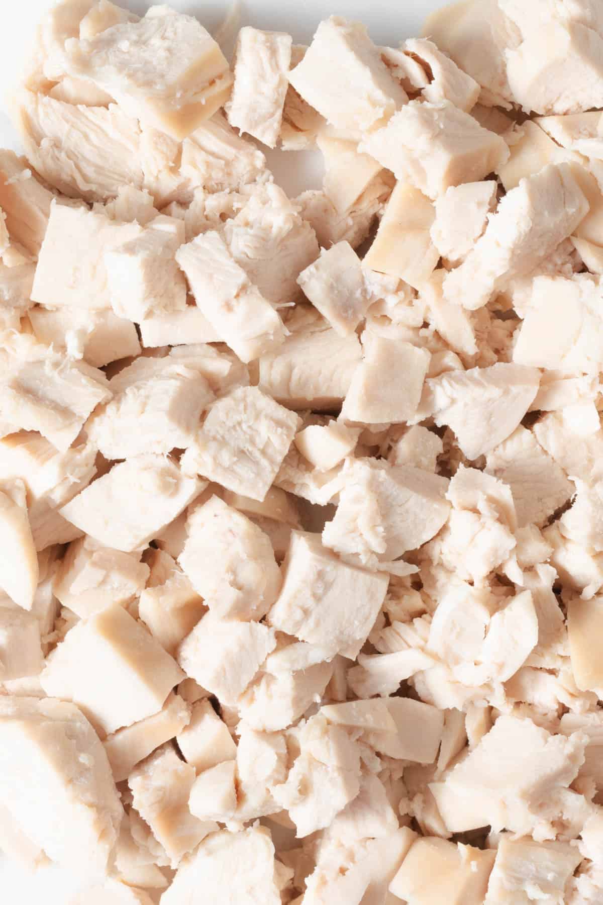 A plate of diced poached chicken breast ready to use in recipes.